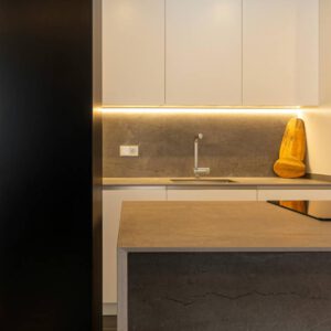 Cocina con península en tonos blancos y gris
